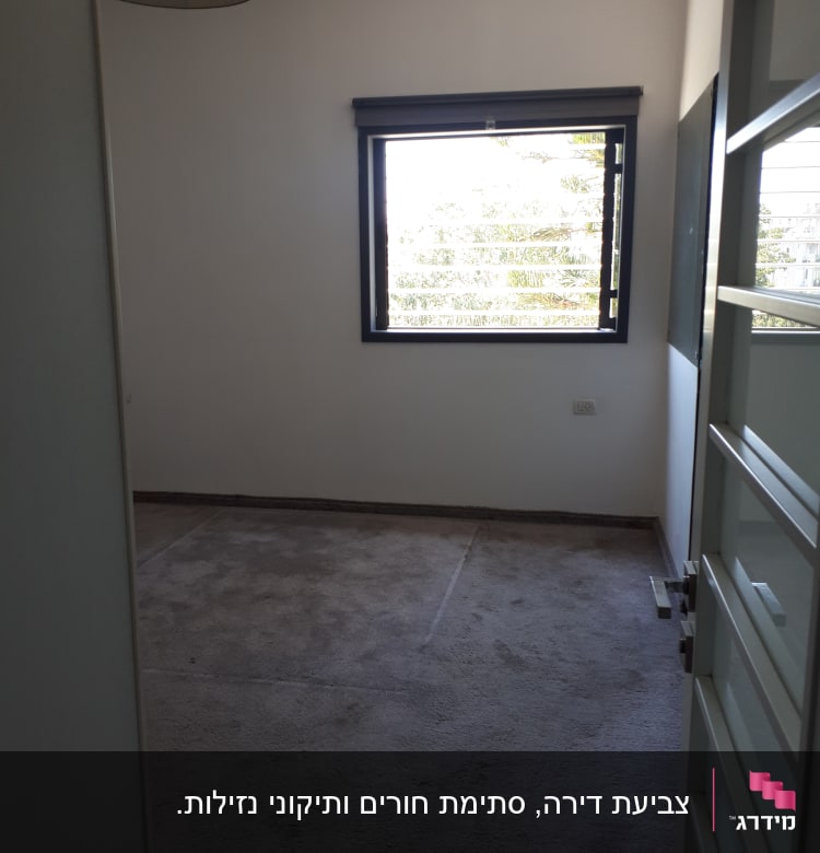 חדר ריק עם קירות לבנים וחלון פתוח